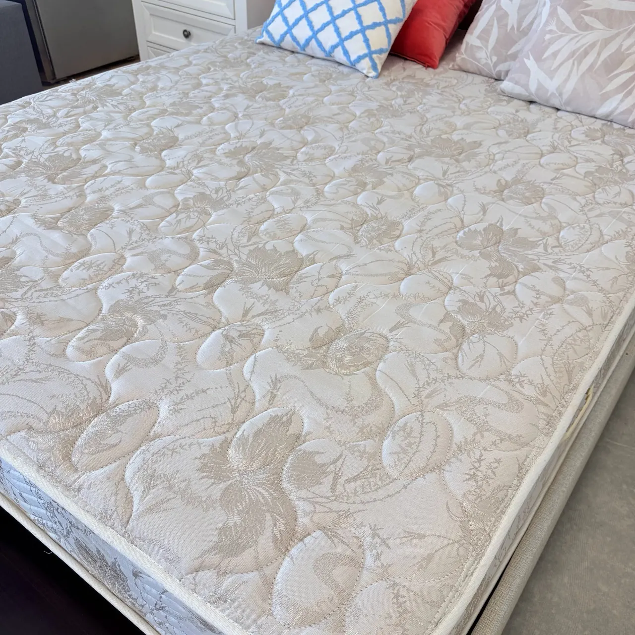 Ther-a-Pedic Back Care Extra Firm queen mattress with a quilted floral damask top, seen from the foot corner