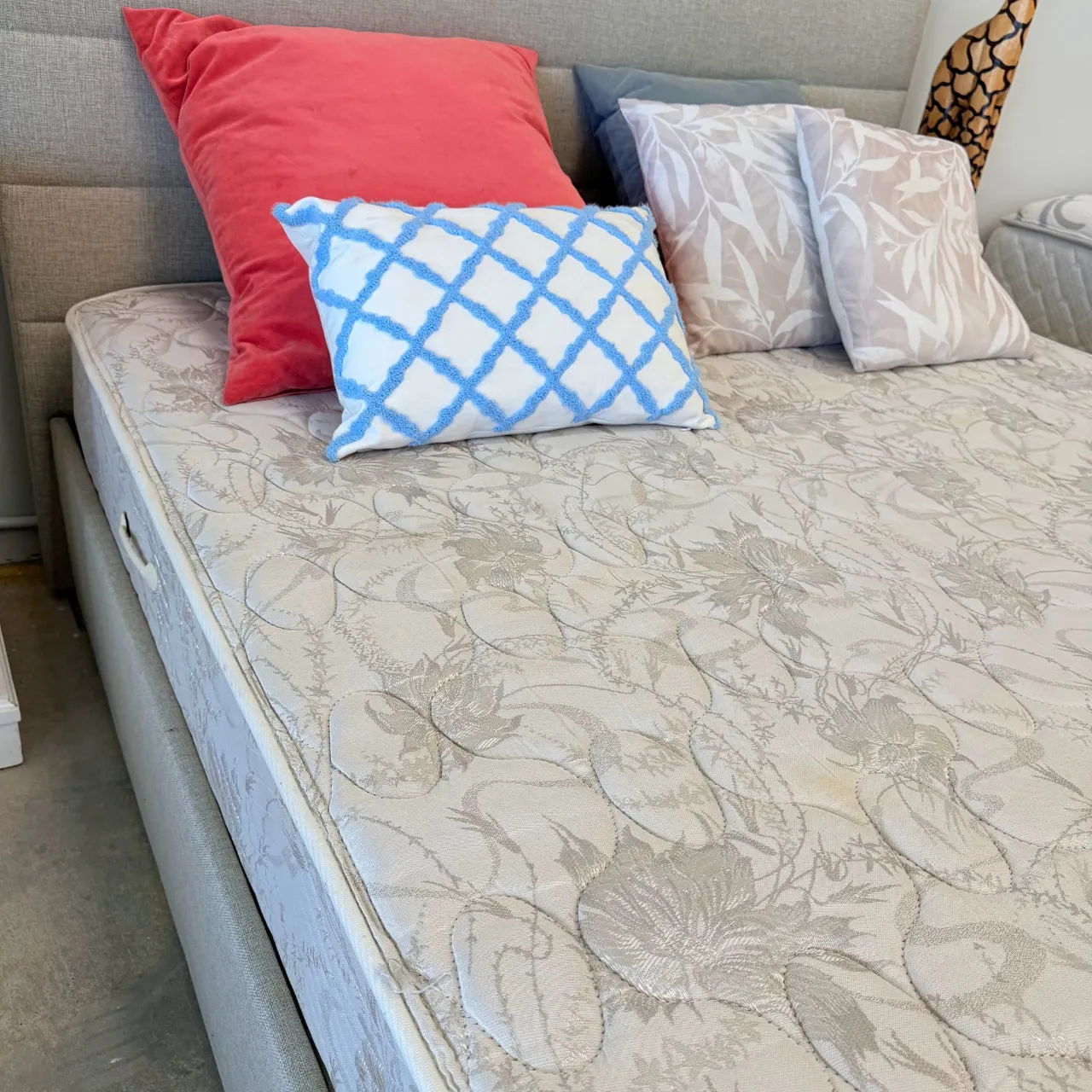 Extra firm queen mattress on the storage bed with cushions, seen from the side near the headboard
