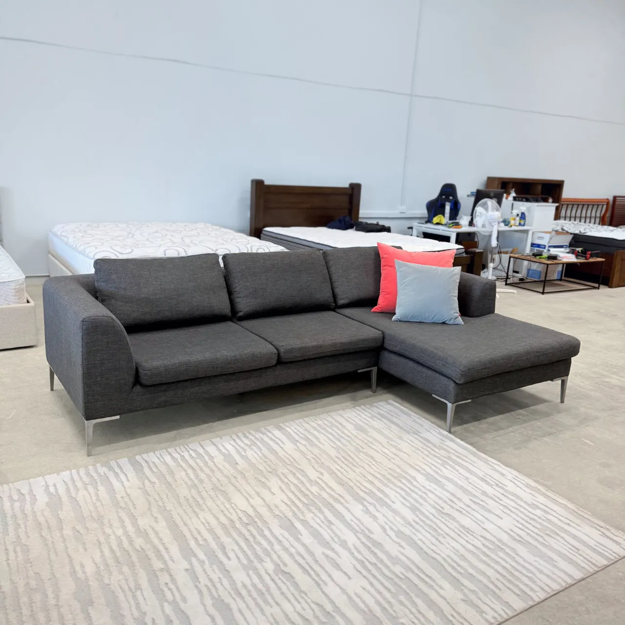 Freedom L shape chaise sofa in dark grey fabric, three-quarter view with the chaise on the right and two scatter cushions