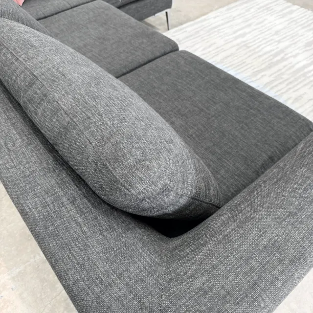 Slim arm and seat cushions of the Freedom sofa in dark grey weave