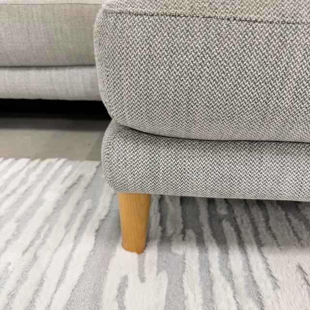 Light timber leg and light grey textured fabric of the chaise base