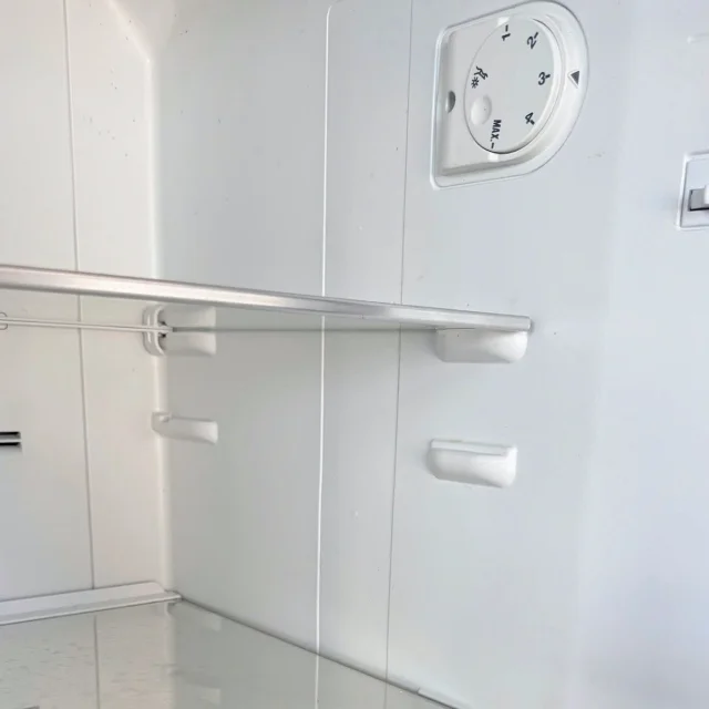 Temperature dial and adjustable glass shelf inside the Beko fridge