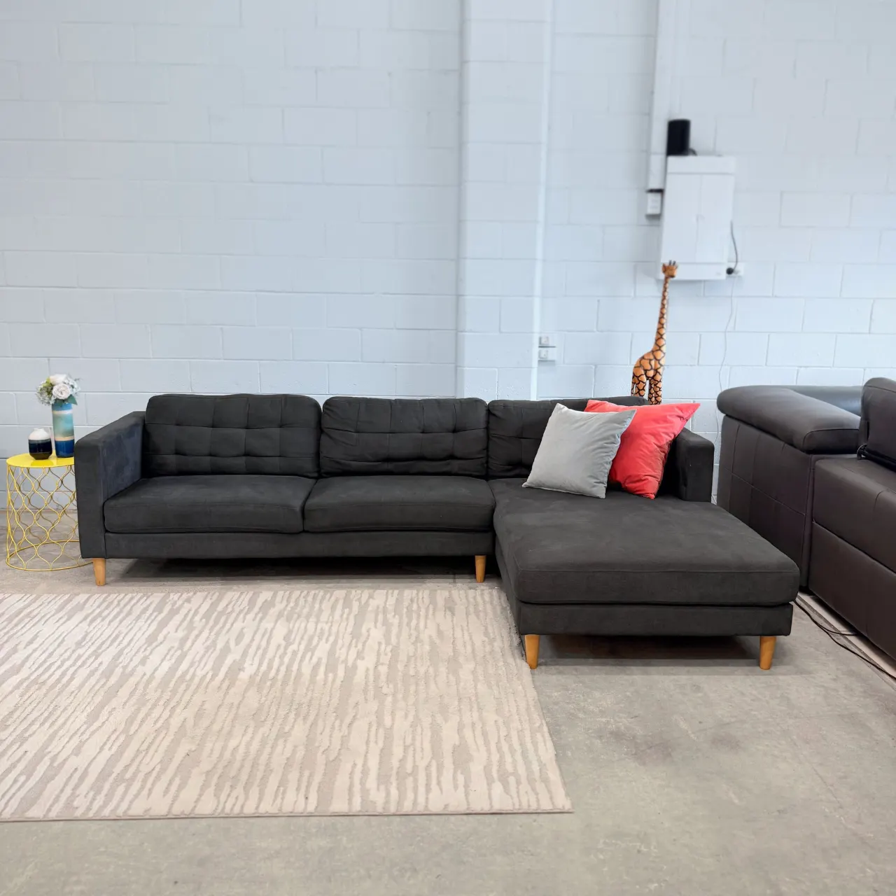 Charcoal L shape chaise sofa, straight-on front view with grey and coral cushions