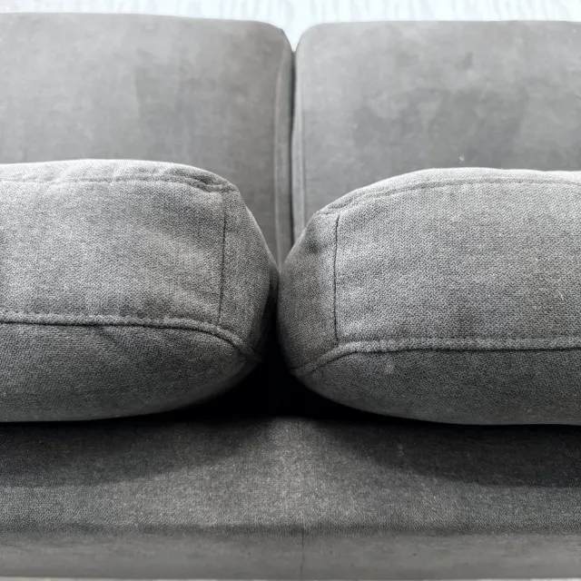 Close-up of the stitched-grid back cushions in charcoal weave