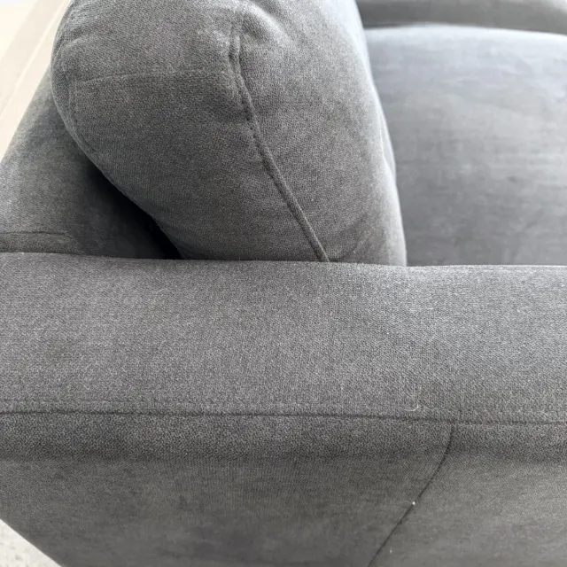 Close-up of the charcoal woven fabric on the arm and back cushion