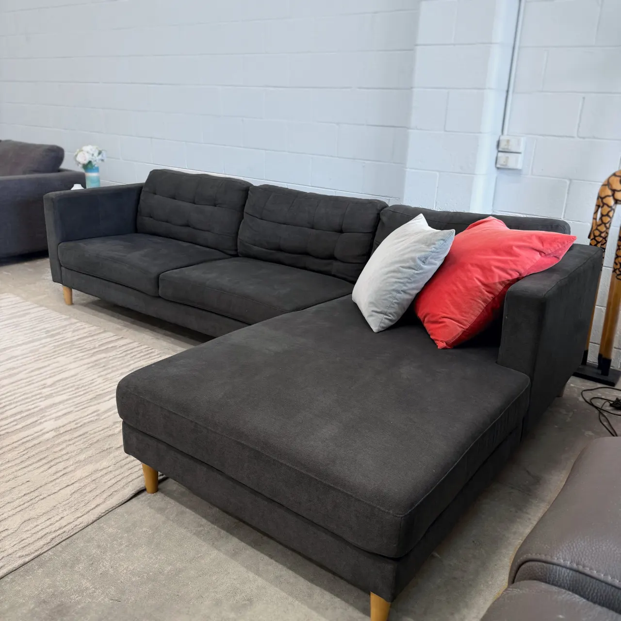 Charcoal tufted L shape sofa with chaise, three-quarter view from the left