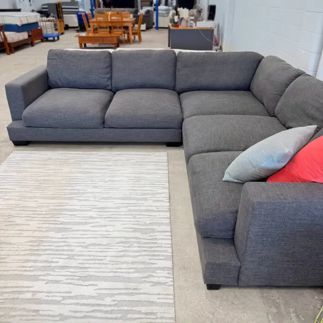 Corner lounge from the front corner: deep seats, soft back cushions and a wide square arm