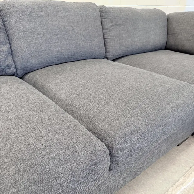 Deep plush seat cushions along one side of the corner lounge