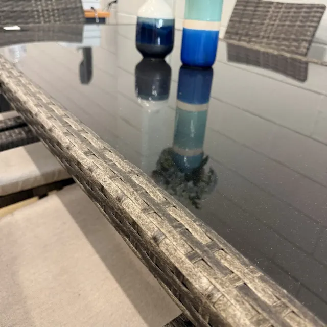 Black glass table top set in the grey-brown wicker frame