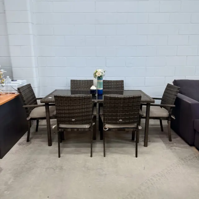 Riva outdoor wicker dining set with a black glass-top table and 6 cushioned armchairs