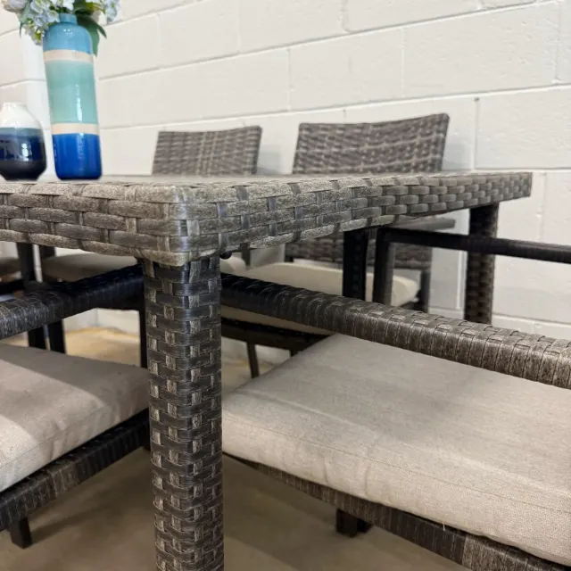 Corner of the wicker dining table with armchairs and cushions