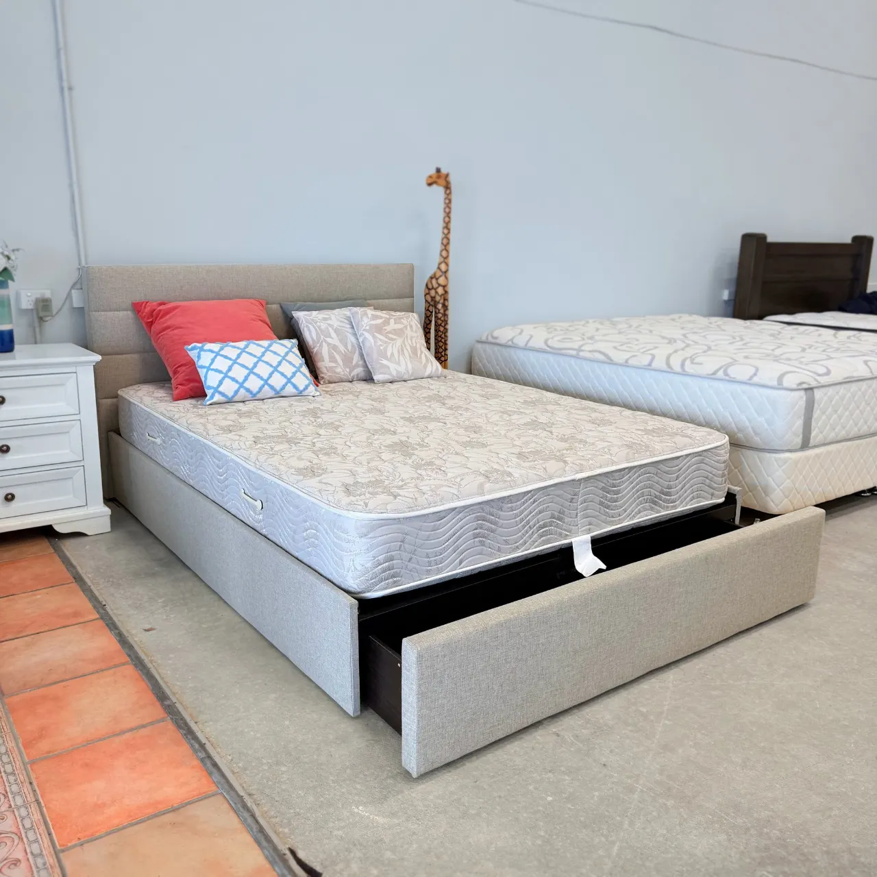 Queen storage bed with the big foot drawer pulled out, shown with a mattress