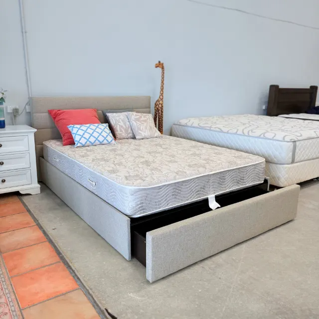 Queen storage bed with the big foot drawer pulled out, shown with a mattress