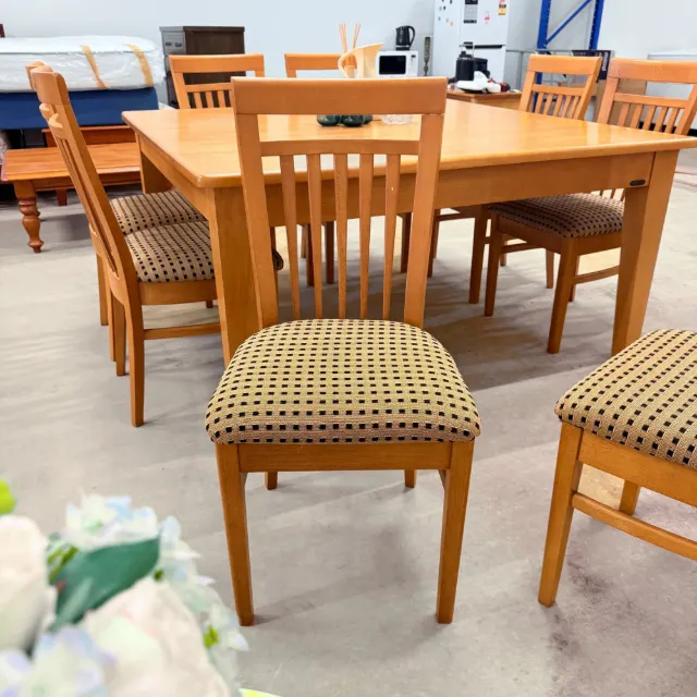 Slat-back dining chair with padded seat in front of the table