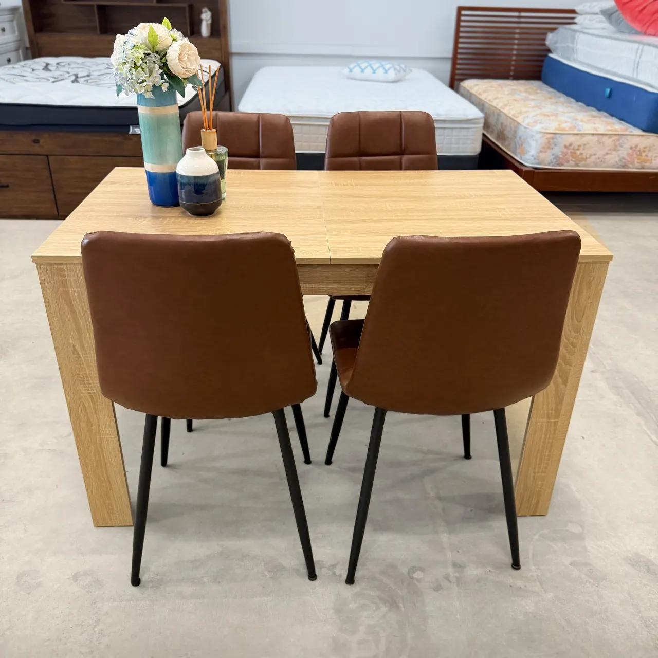Oak look dining table with 4 tan faux leather chairs, front view