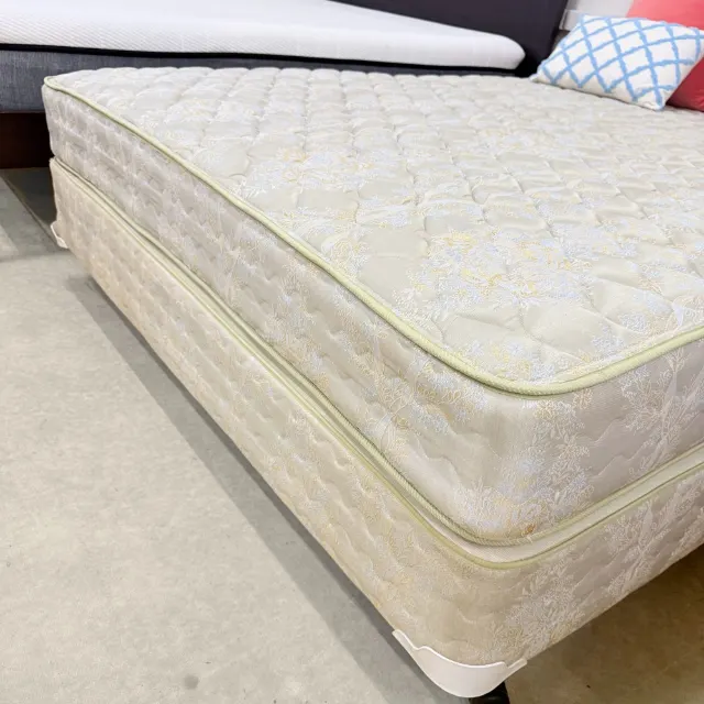 Corner of the quilted damask mattress on its matching Sealy base
