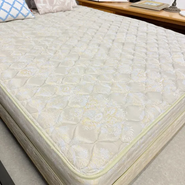 Close-up of the quilted cream damask mattress top and piped edge