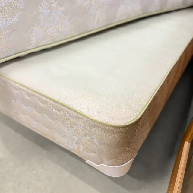 Plain top of the Sealy base and its piped edge, mattress lifted
