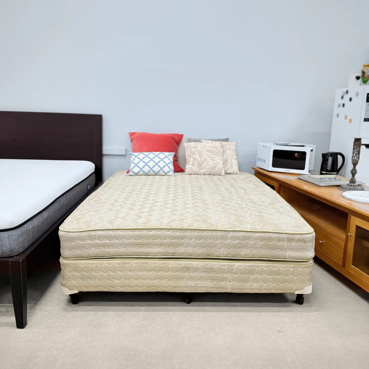 Sealy queen ensemble seen from the foot, matching base and mattress on castors