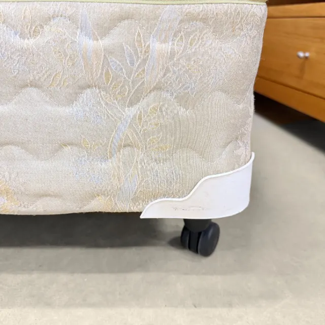 Base corner with a protective corner guard and castor wheel