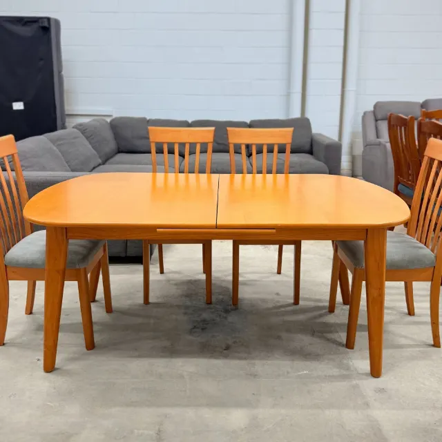 Timber dining table with rounded ends and a chair at each end