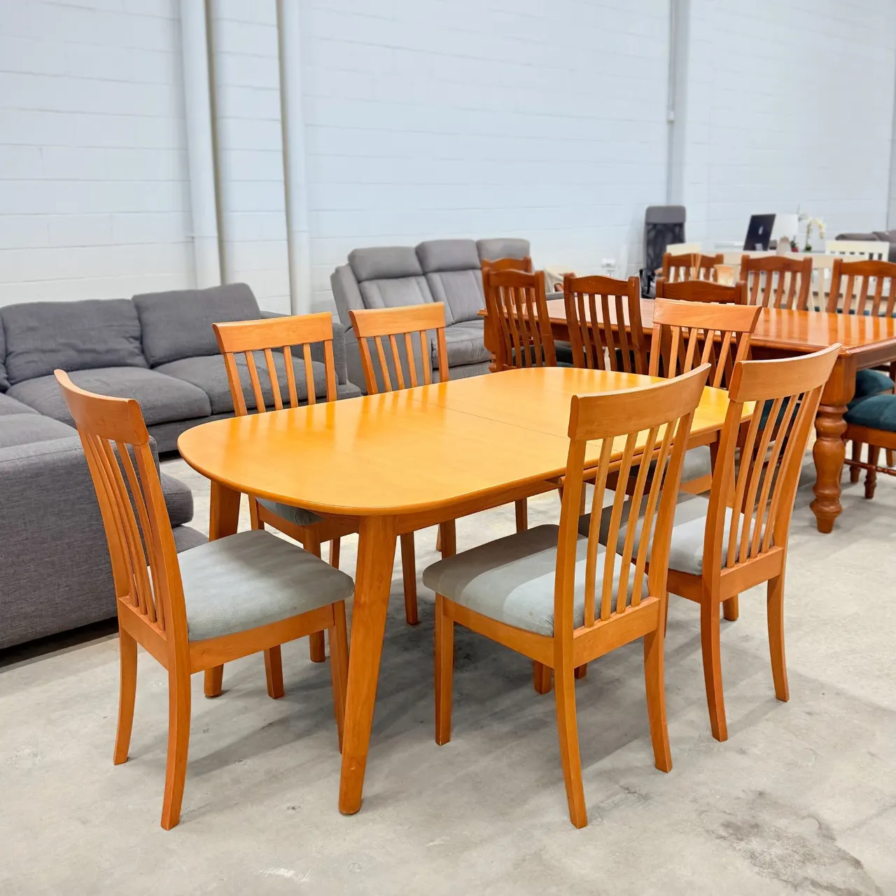 Timber dining set from a side angle, table with six slatted high-back chairs