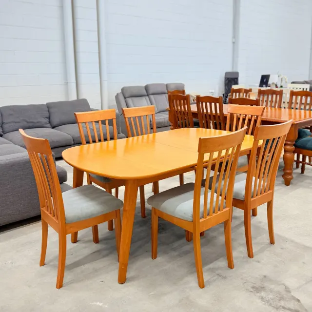 Timber dining set from a side angle, table with six slatted high-back chairs