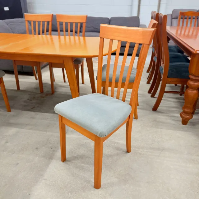 Dining chair from a side angle showing the slatted back and timber legs