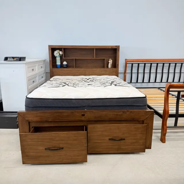 Queen pillow top mattress on a walnut storage bed in the showroom, front view
