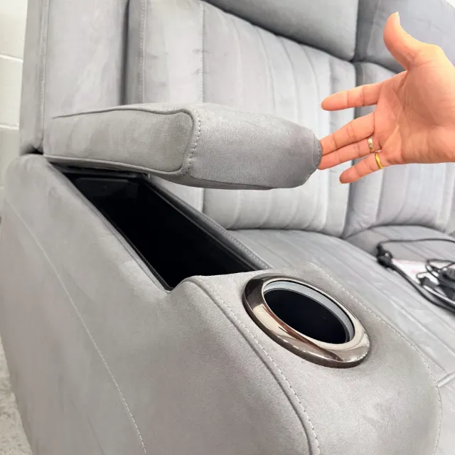 Arm rest lid lifted to show the storage box and cup holder