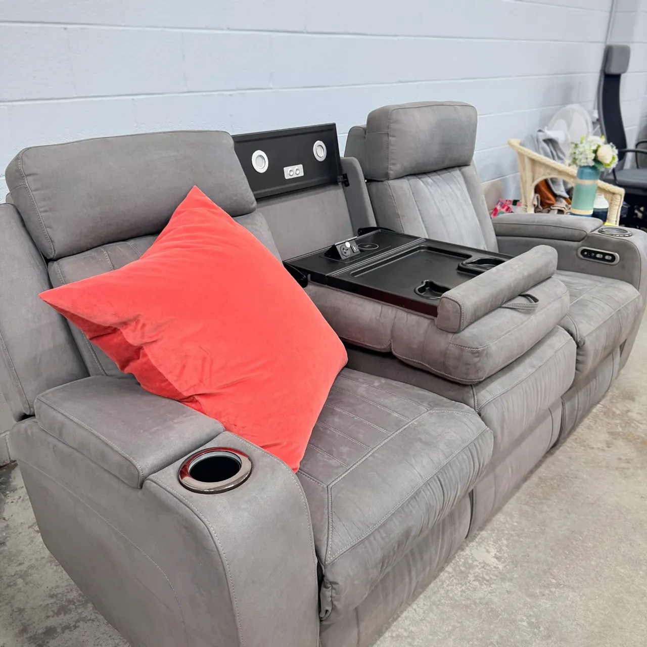 Grey recliner sofa at an angle with the drop-down console open