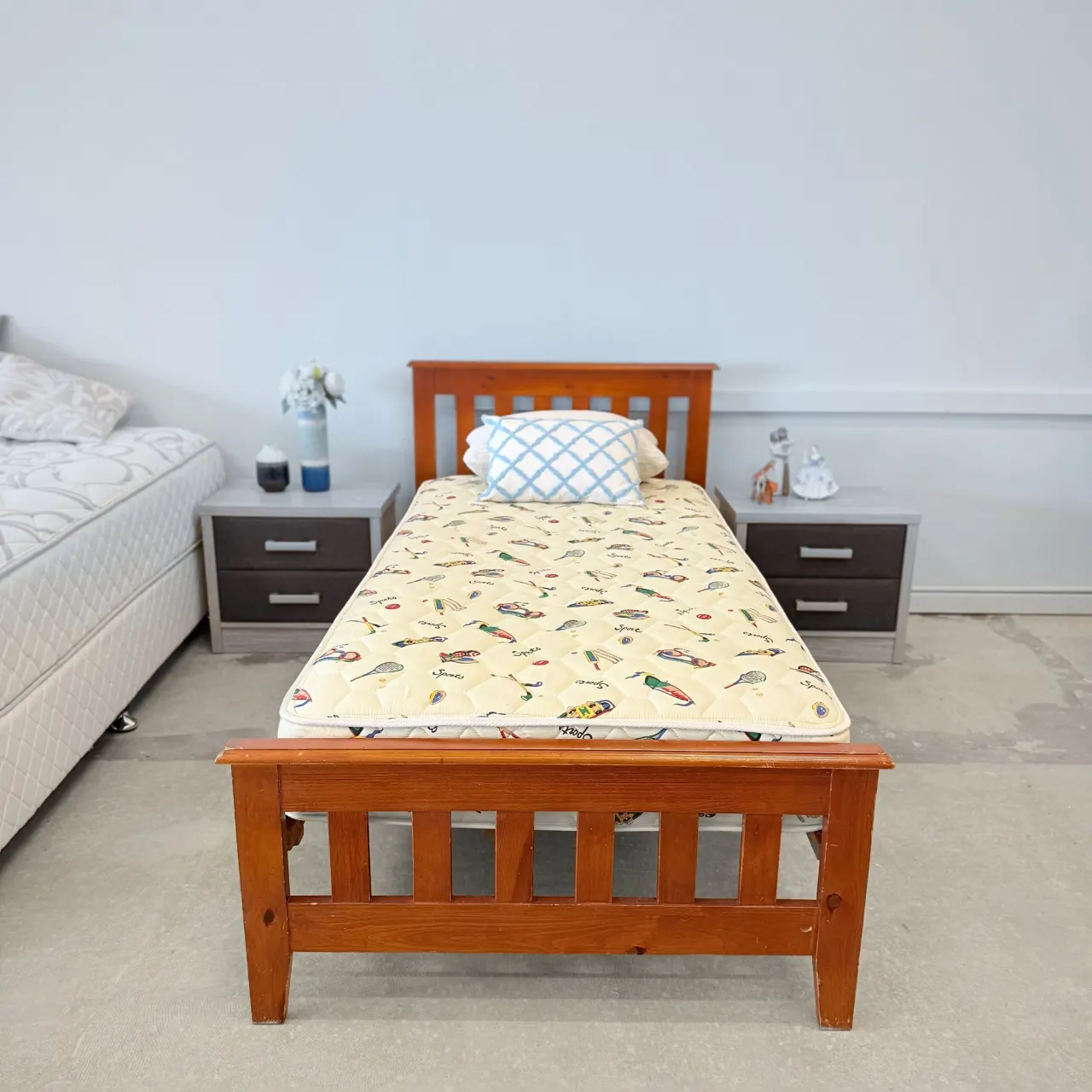 Timber single bed with a kids’ mattress, front view