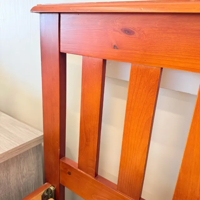 Slatted headboard in warm cherry-stained timber, close-up