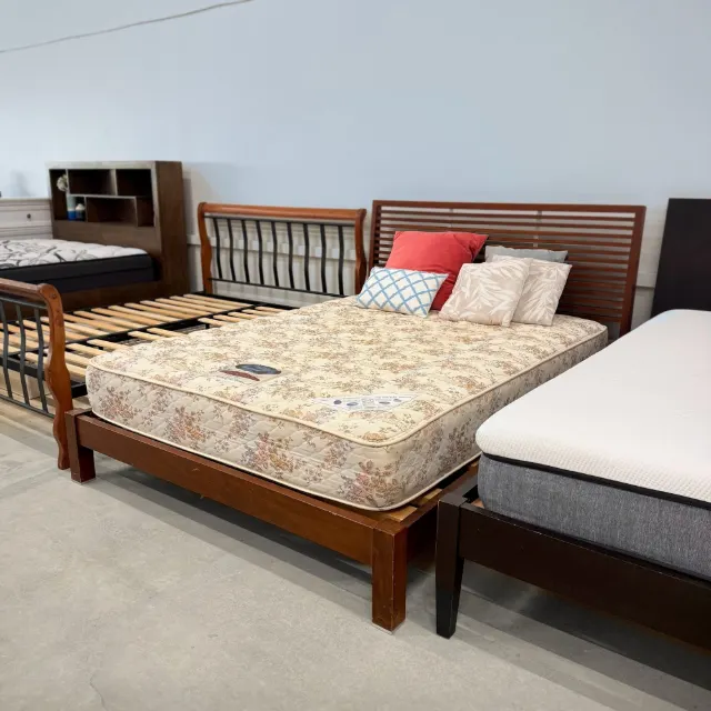 Walnut queen bed with mattress at an angle