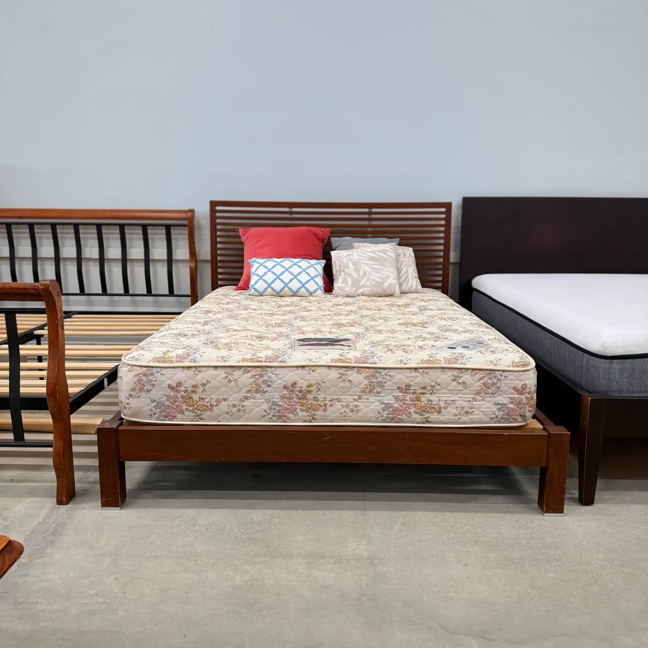 Walnut timber queen bed with a Sealy mattress, front view